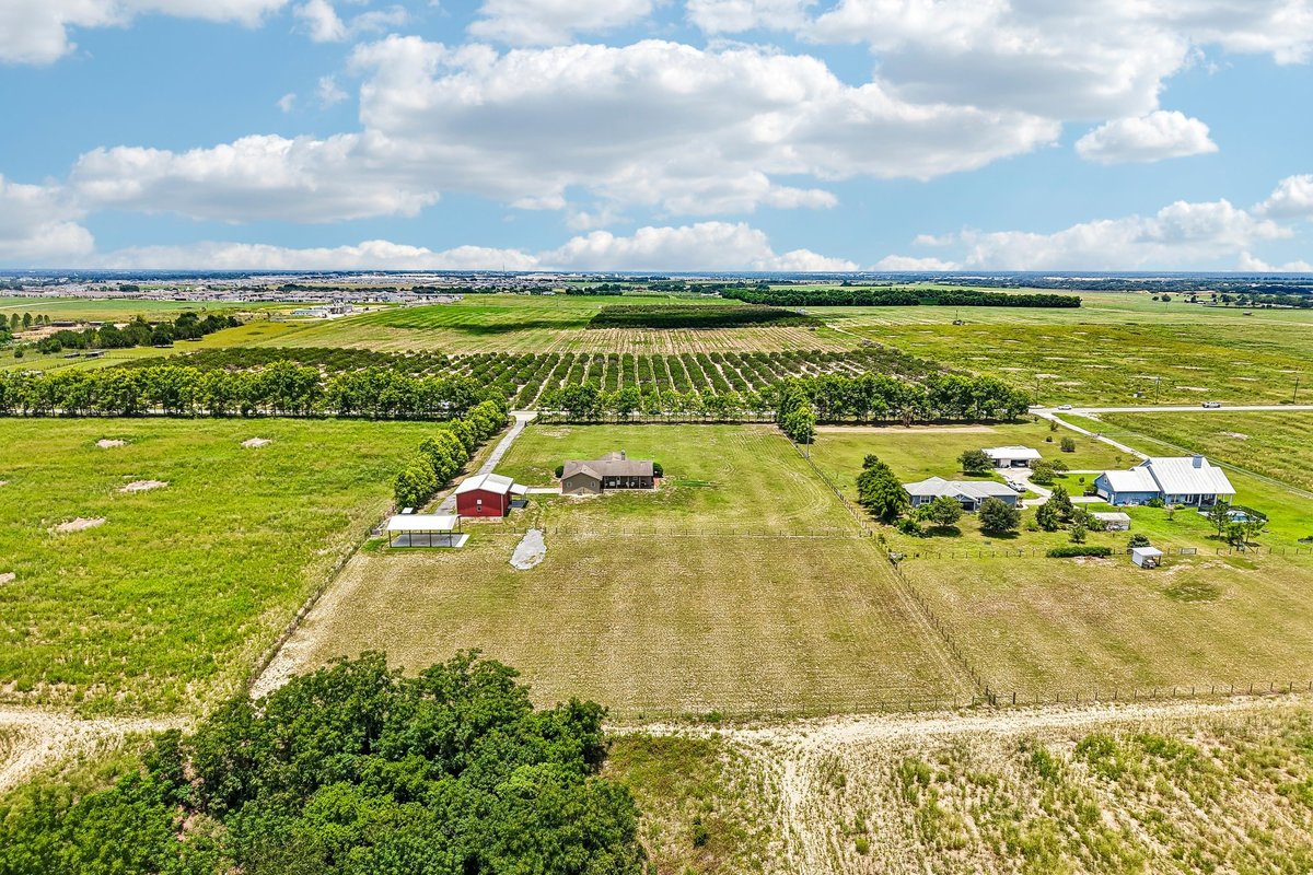 Twilight hero image of country-style Haines City home with red workshop and open land