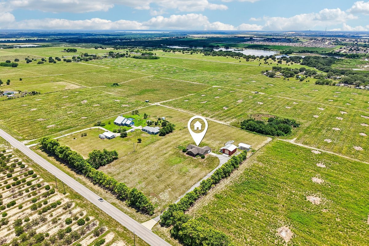 Wide exterior view of rural-style home and workshop on private acreage in Haines City