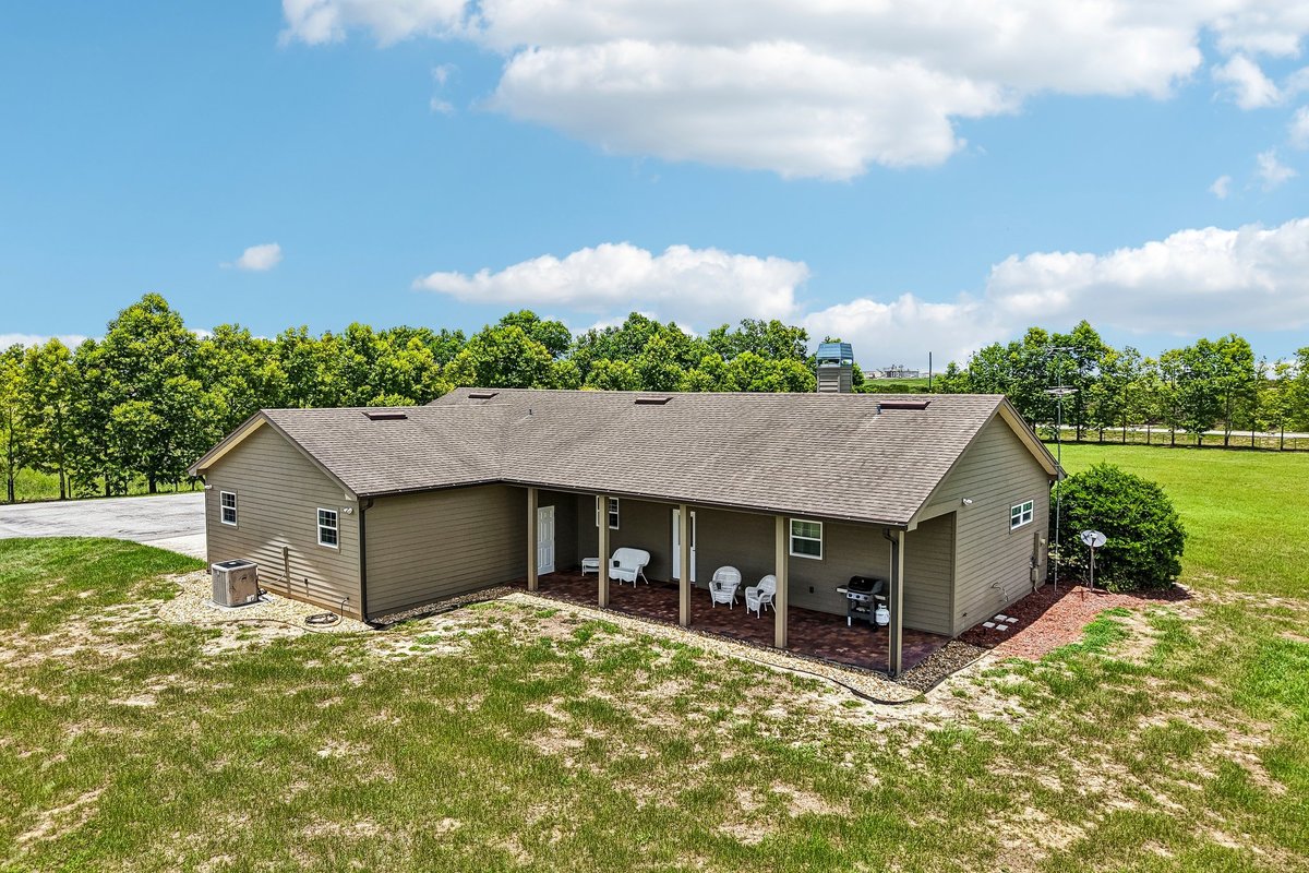 Front elevation of custom Haines City home with covered porch, red door, and lawn