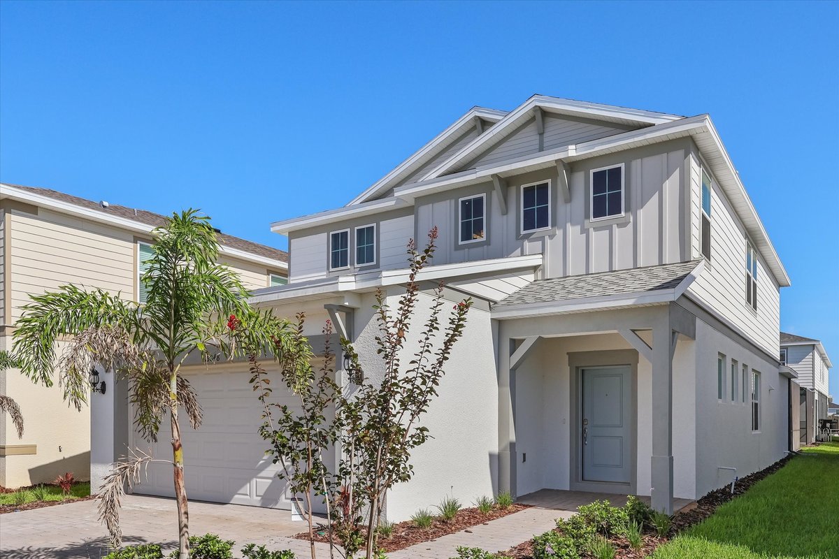 Daytime exterior of a modern two-story Windsor Cay vacation home with clean lines and tropical landscaping.