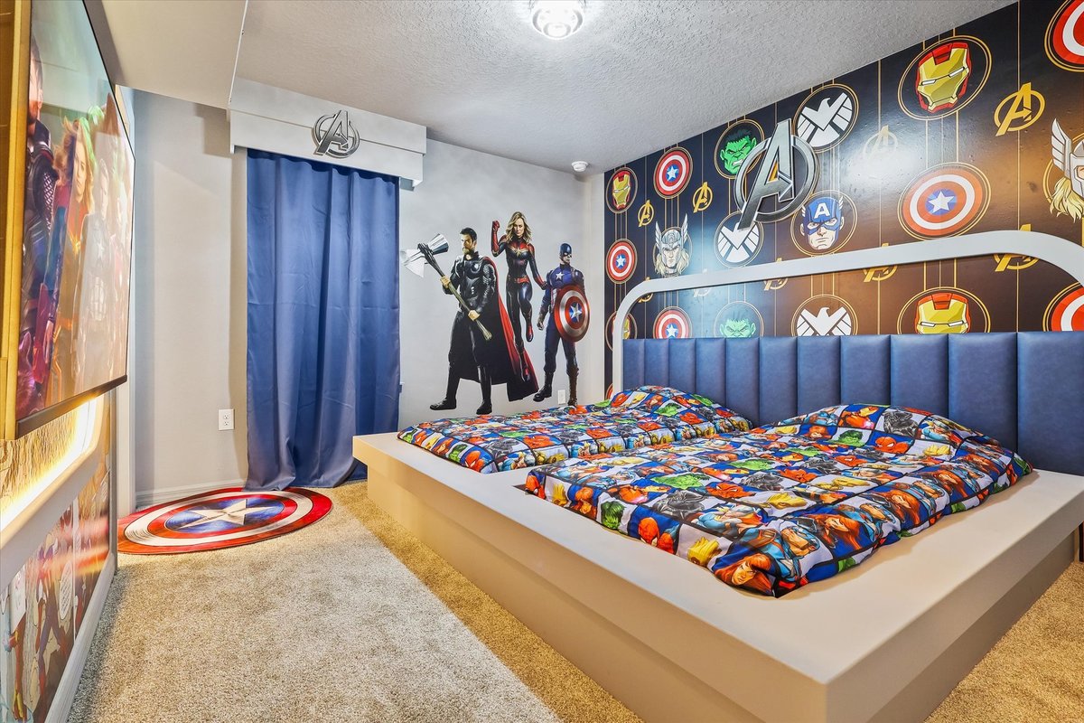 Superhero-themed bedroom with bold wall graphics, character bedding and playful comic-inspired decor.
