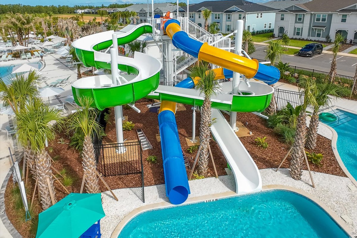 Colorful water slides and splash area at Windsor Cay Resort, surrounded by palms and family amenities.