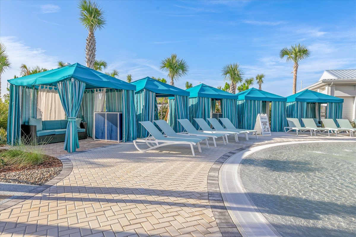 Poolside cabanas and lounge chairs at Windsor Cay Resort with turquoise accents and tropical landscaping.