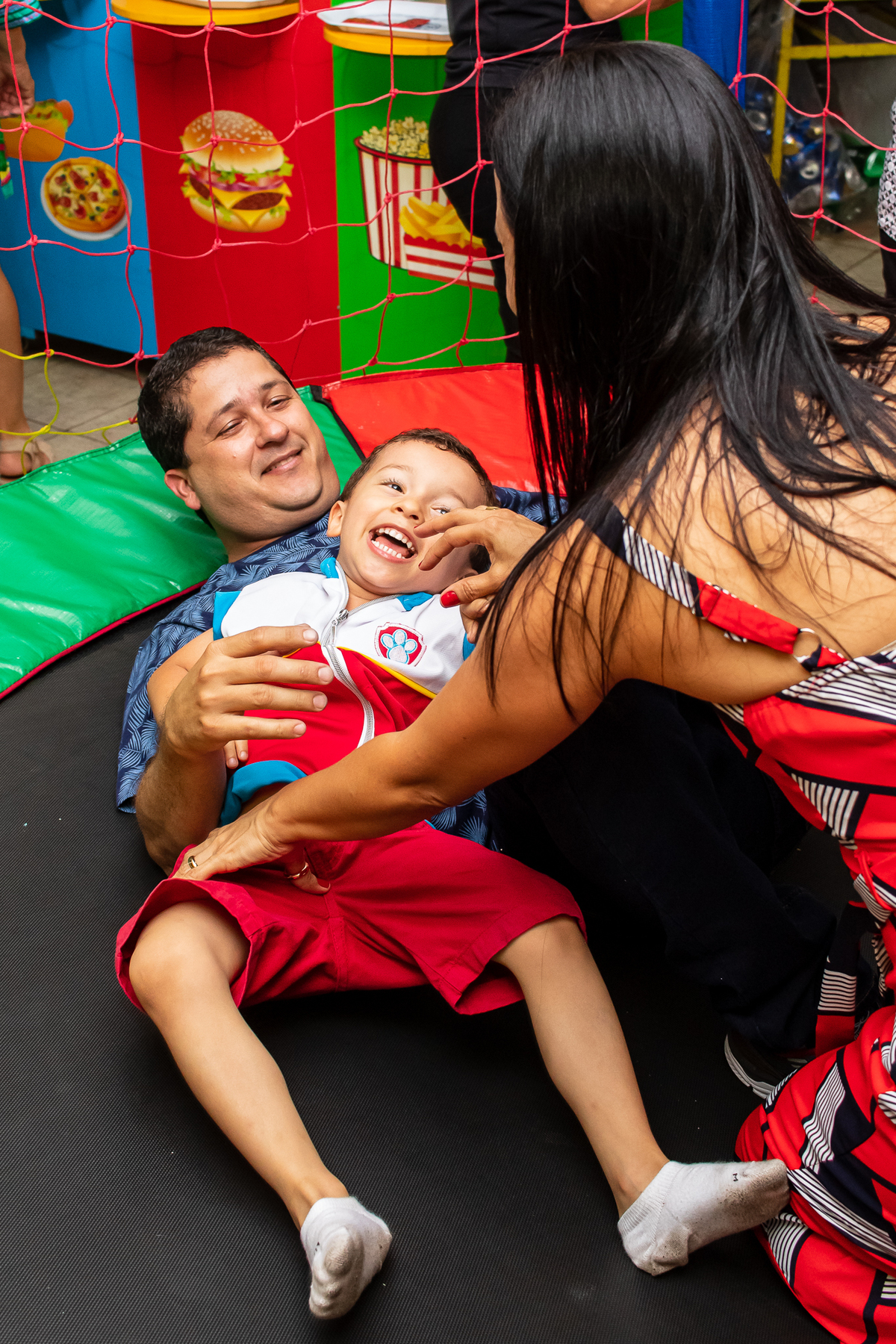 Brincando no pula pula com os pais.