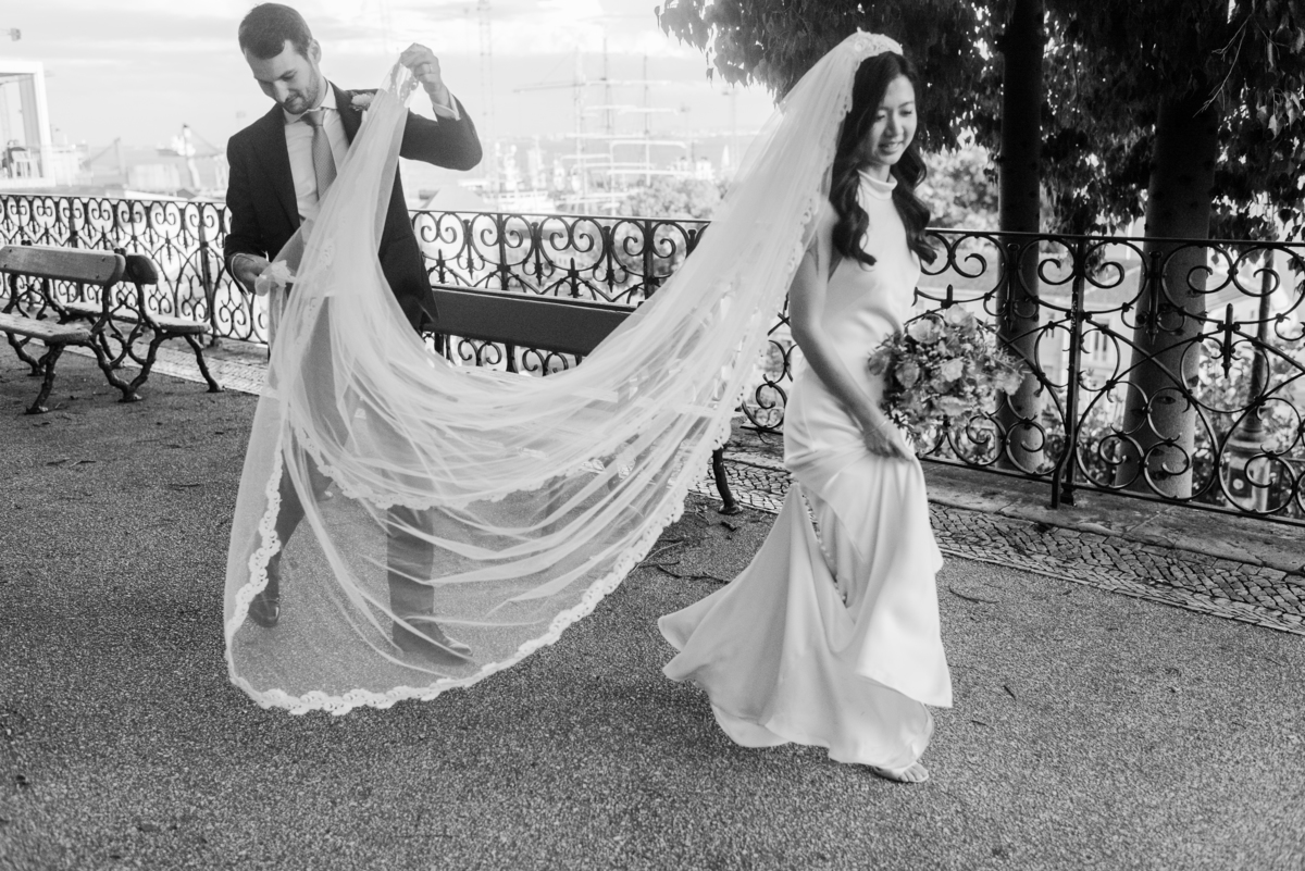 Groom-holding-Bride's-veil