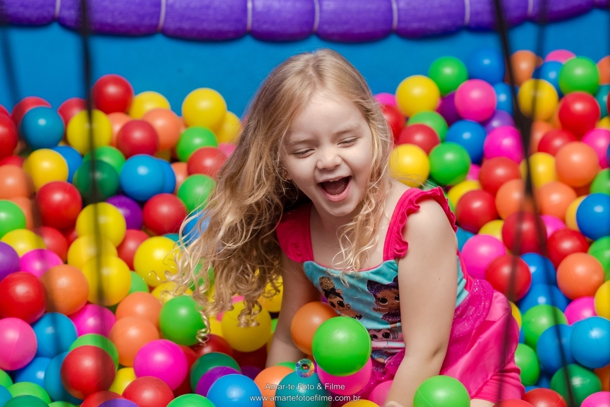 festa infantil tema lol decoração criança posando 4 anos piscina de bolinhas