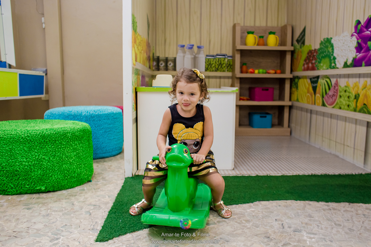 menina de 3 anos vestida de queen b em sua festa de aniversário do tema lol e brincando no cavalinho