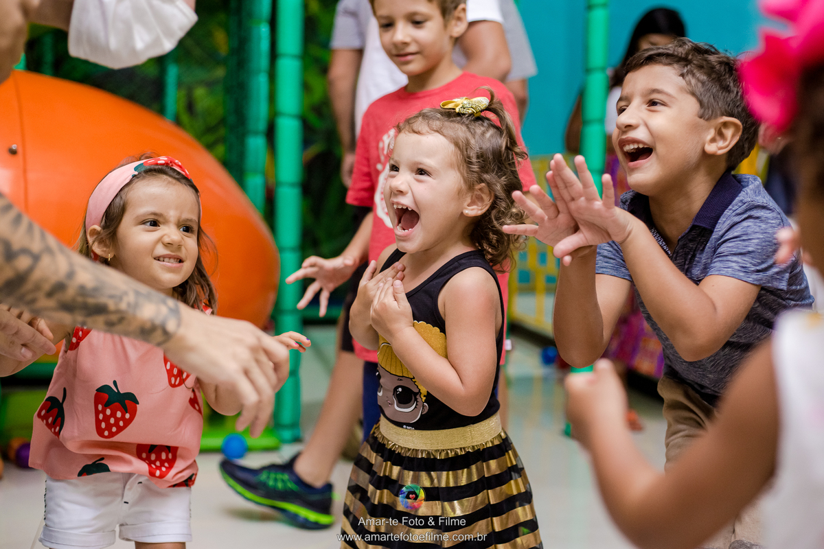 menina de 3 anos vestida de queen b em sua festa de aniversário do tema lol e sorrindo com brincadeiras