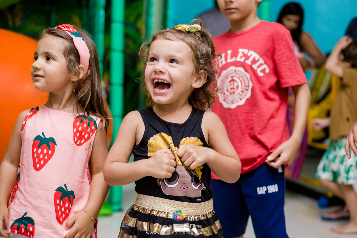 menina de 3 anos vestida de queen b em sua festa de aniversário do tema lol e sorrindo com brincadeiras