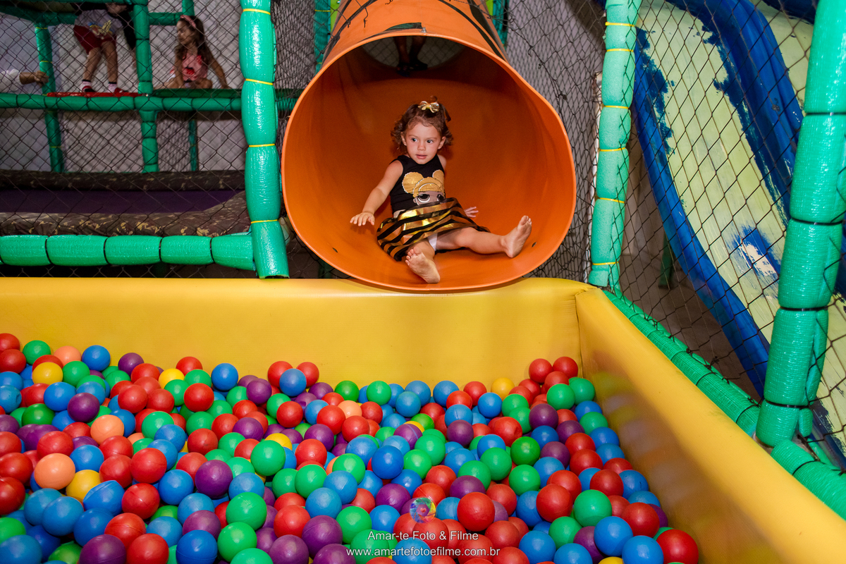 menina de 3 anos vestida de queen b em sua festa de aniversário do tema lol e sorrindo com brincadeiras