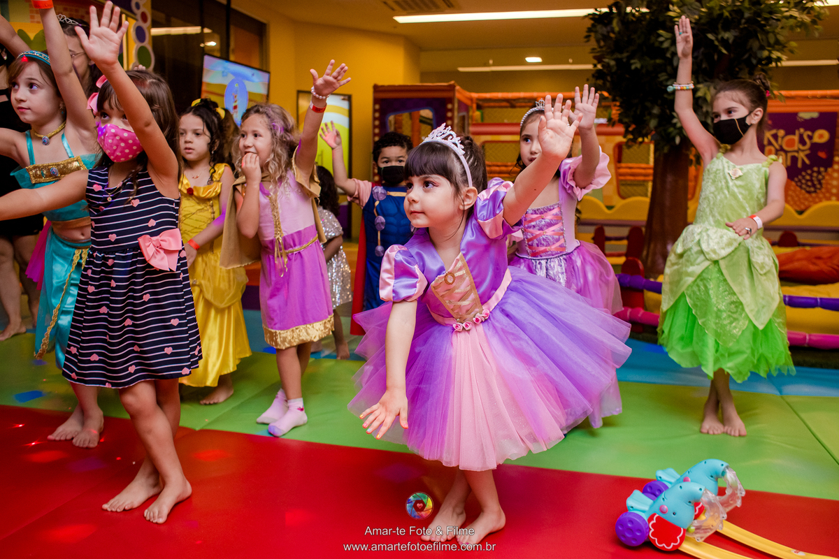 menina vestida de princesa rapunzel brincando no kids park de estátua