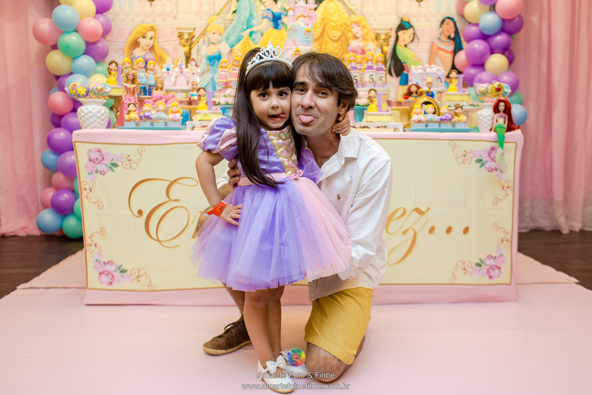 pai e filha lingua de fora posando para foto mesa do bolo decoração tema princesas no kids park rio casa shopping