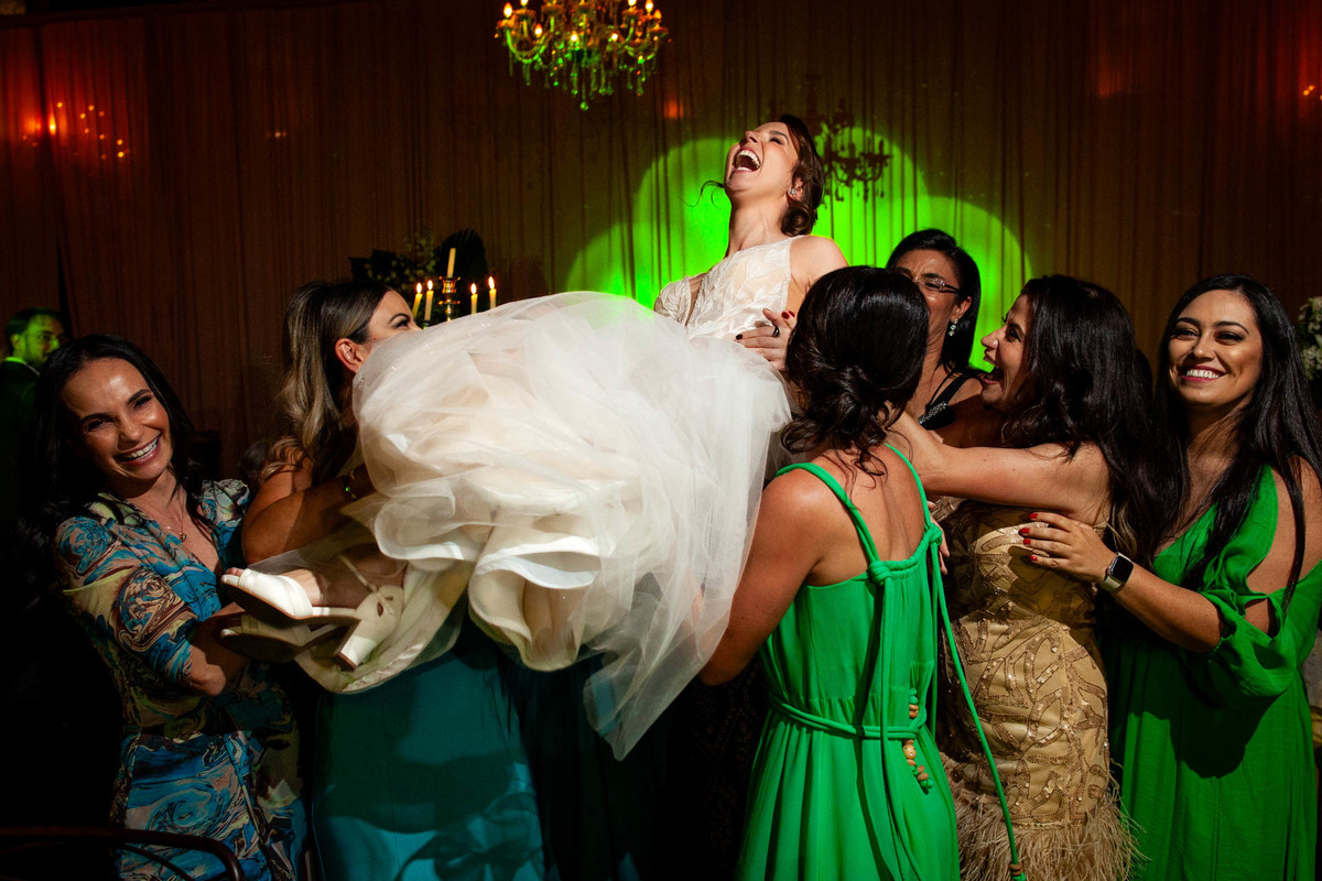 Noiva sendo jogada pra cima pelas amigas