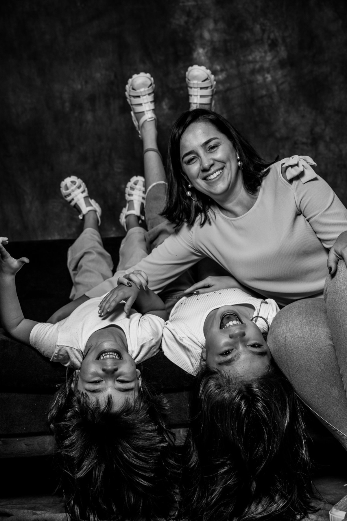 Mãe e filhas brincando no sofá