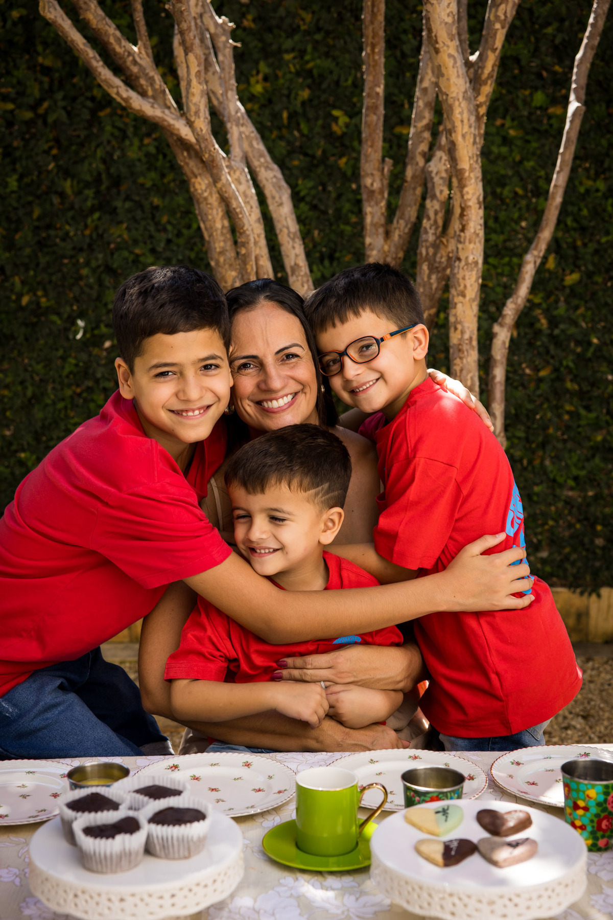 Filhos dão um abraço apertado na mãe