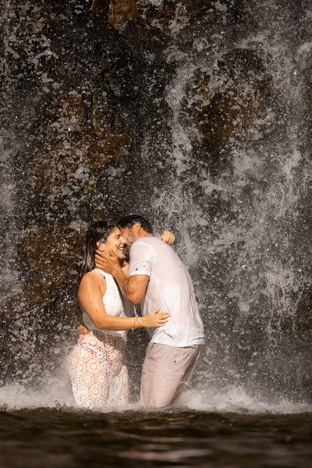Noivos molhados pela água da cachoeira