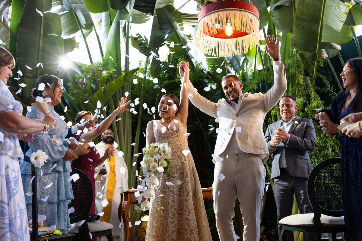 Casal saindo da cerimônia com chuva de pétalas