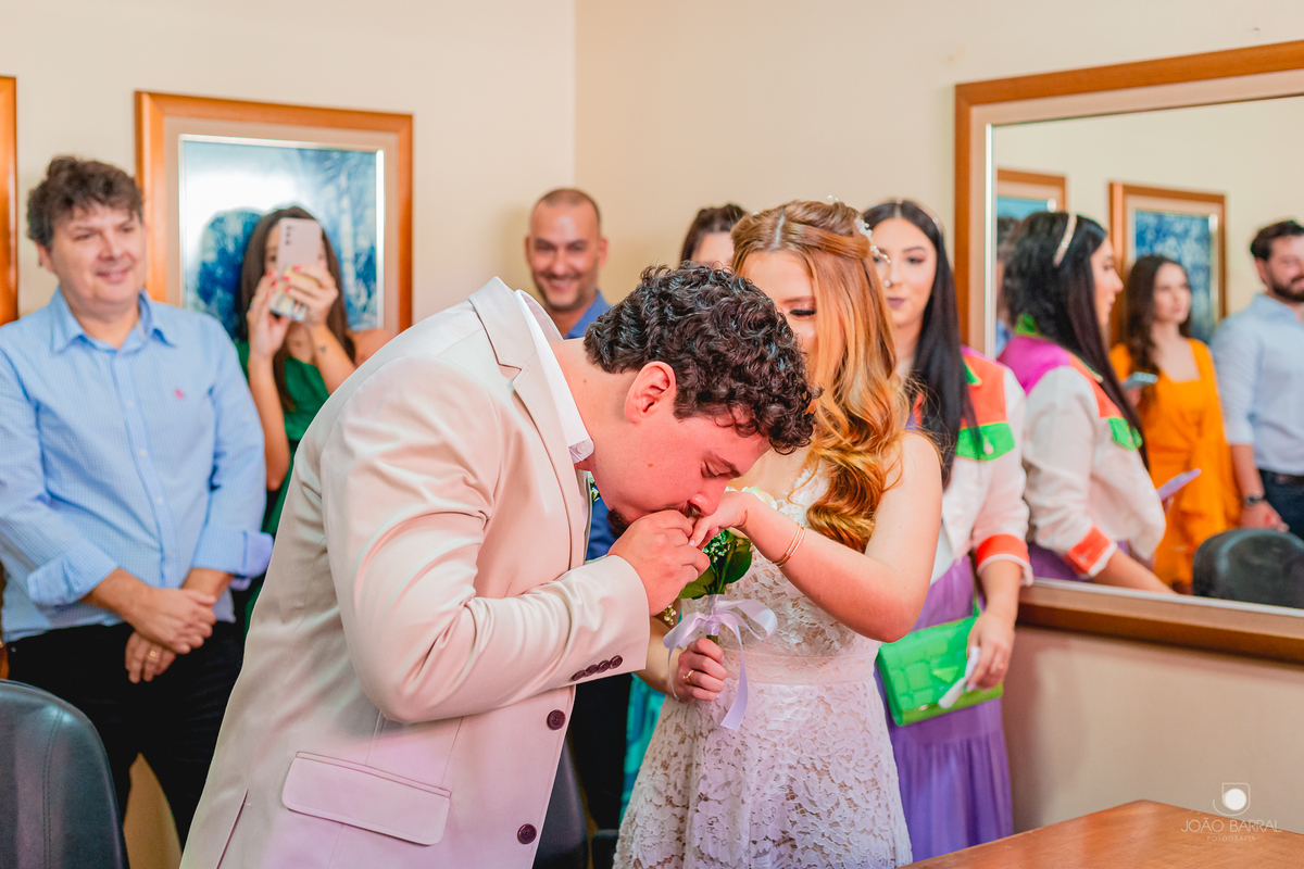 noivo beijando mão e aliança da noiva em cerimônia civil no cartório