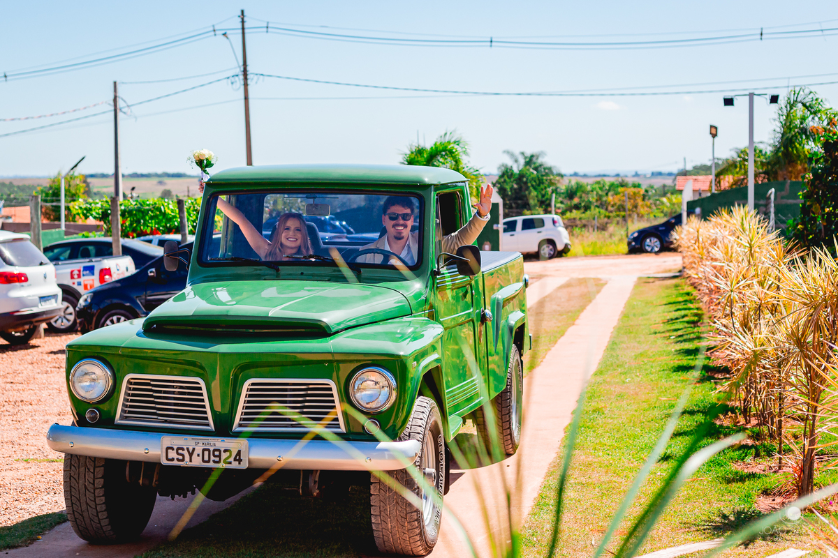 casal feliz chegando em festa de casamento em caminhonete verde 