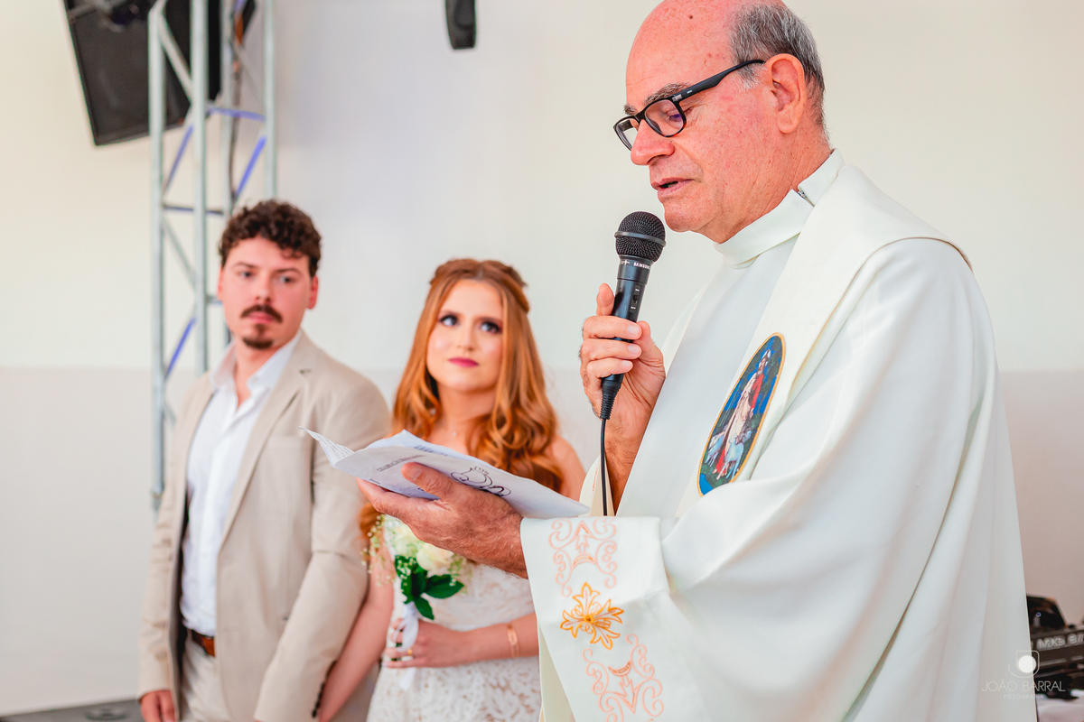 padre dando a benção em casal em casamento