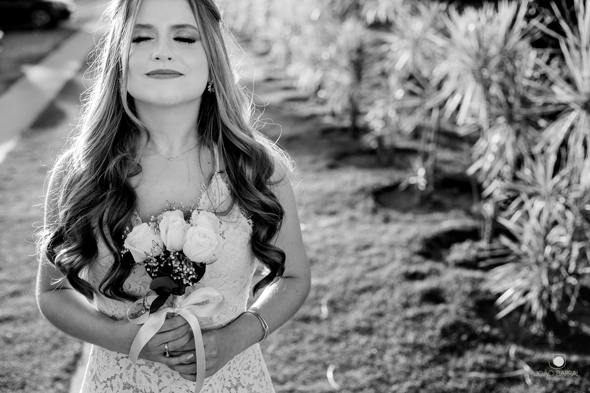 foto preto e branco de noiva segurando buquê com jardim  