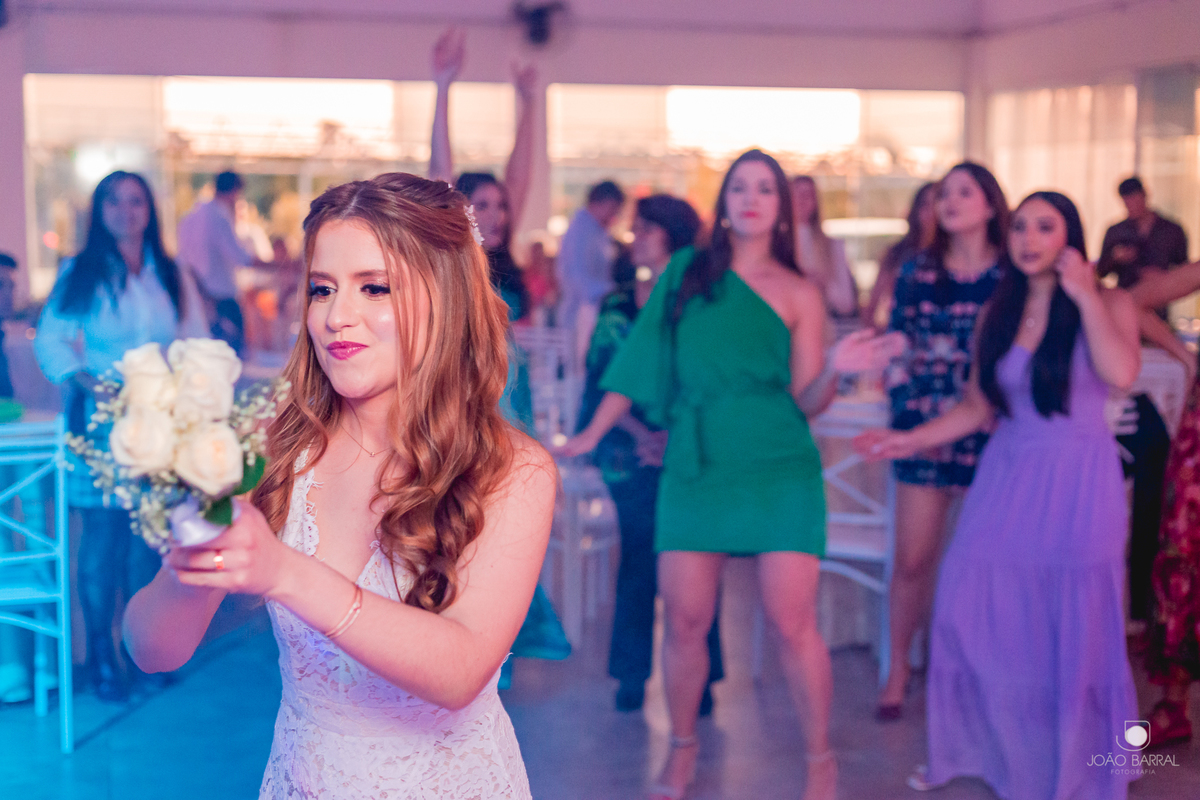 noiva em festa de casamento jogando buque para madrinhas solteiras