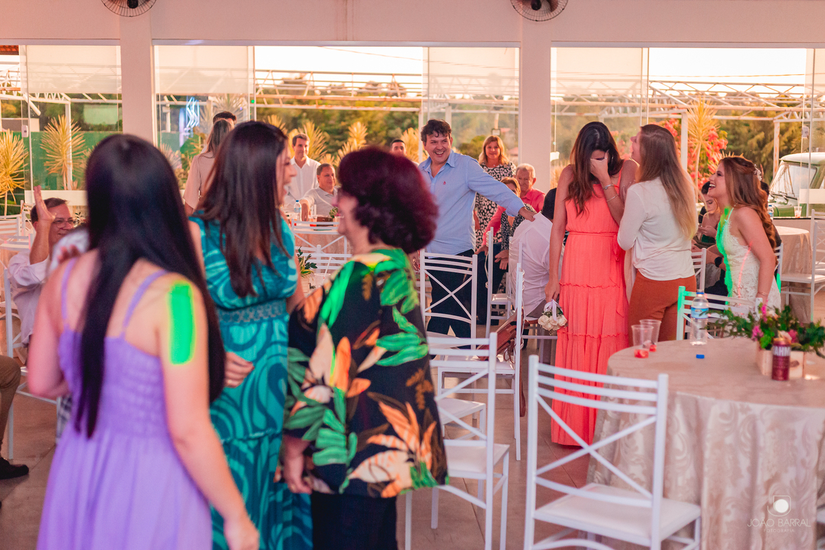 noiva em festa de casamento jogando buque para madrinhas solteiras