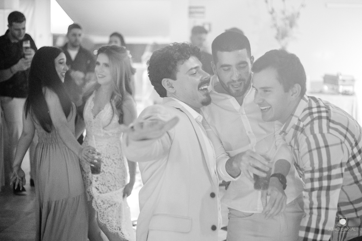 foto em preto e branco do noivo e padrinhos dançando em festa de casamento