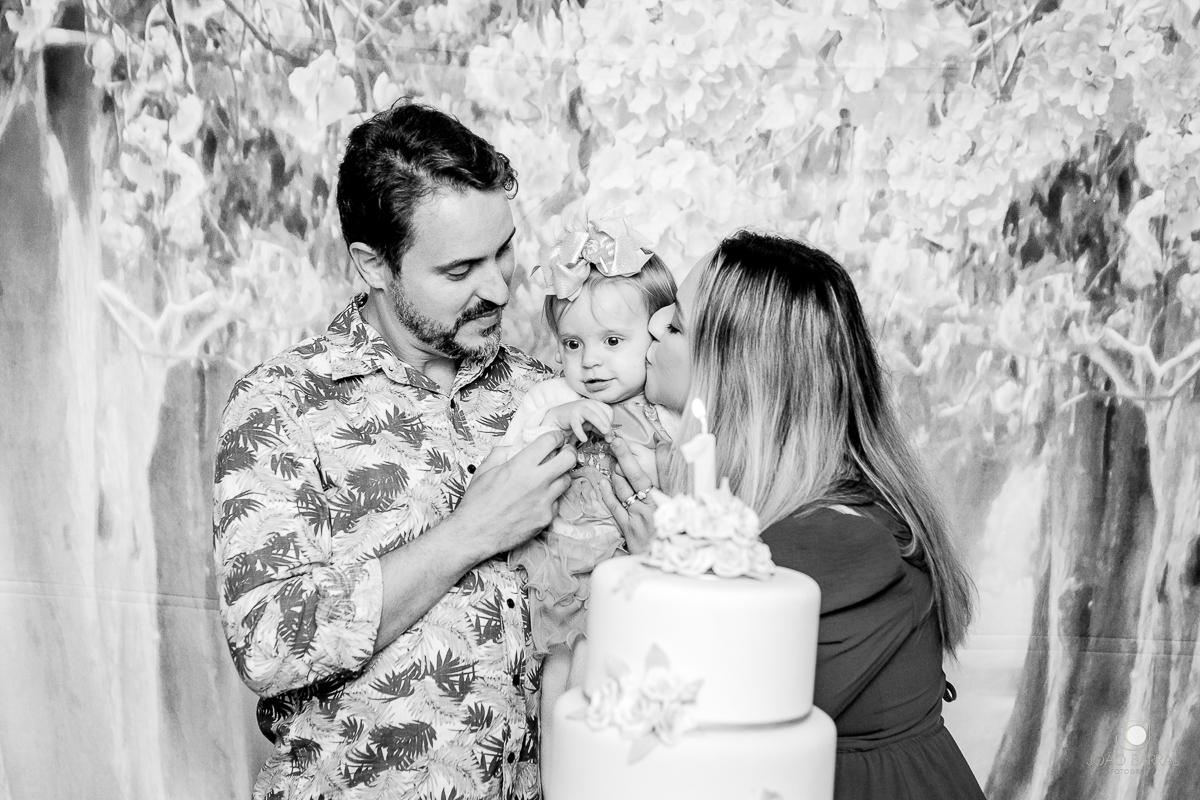 mãe beija filha no momento do parabéns em festa de aniversário infantil