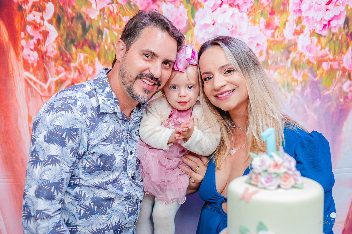 pai, mãe e filha posando para foto em festa de aniversário infantil