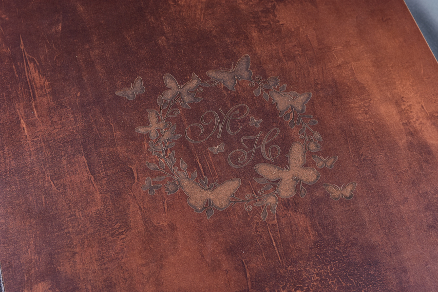 Álbum 30x60 e outros tamanhos, capa com visor de foto em papel metalizado e protegida por acrílico, feito em madeira, com pintura dourada nas páginas, nome dos noivos entalhado a laser e caixa com a logo dos noivos entalhada a laser