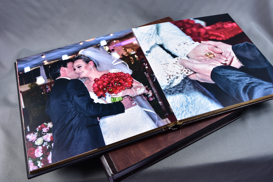 Álbum 30x60 e outros tamanhos, capa com visor de foto em papel metalizado e protegida por acrílico, feito em madeira, com pintura dourada nas páginas, nome dos noivos entalhado a laser e caixa com a logo dos noivos entalhada a laser