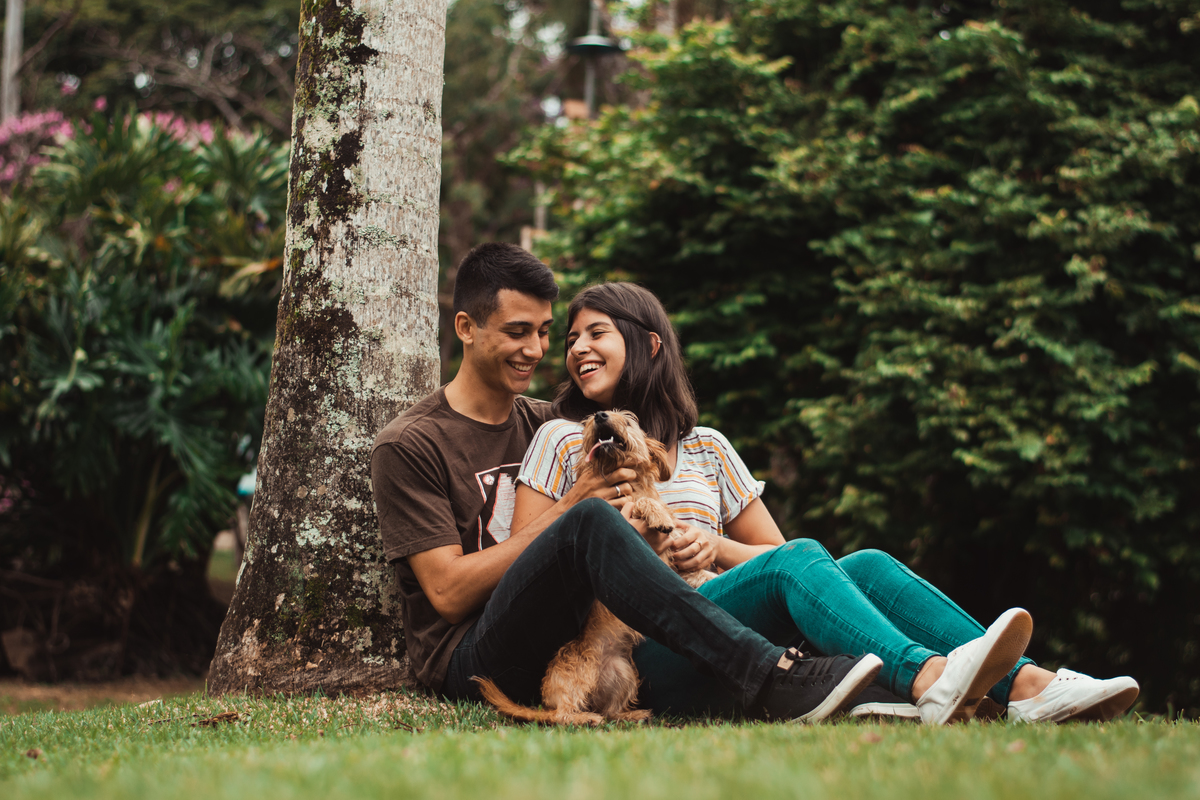 casal sentado na grama com cachorrinho da família, muito amor, cachorro e casal, ensaio no parque de france em joinville