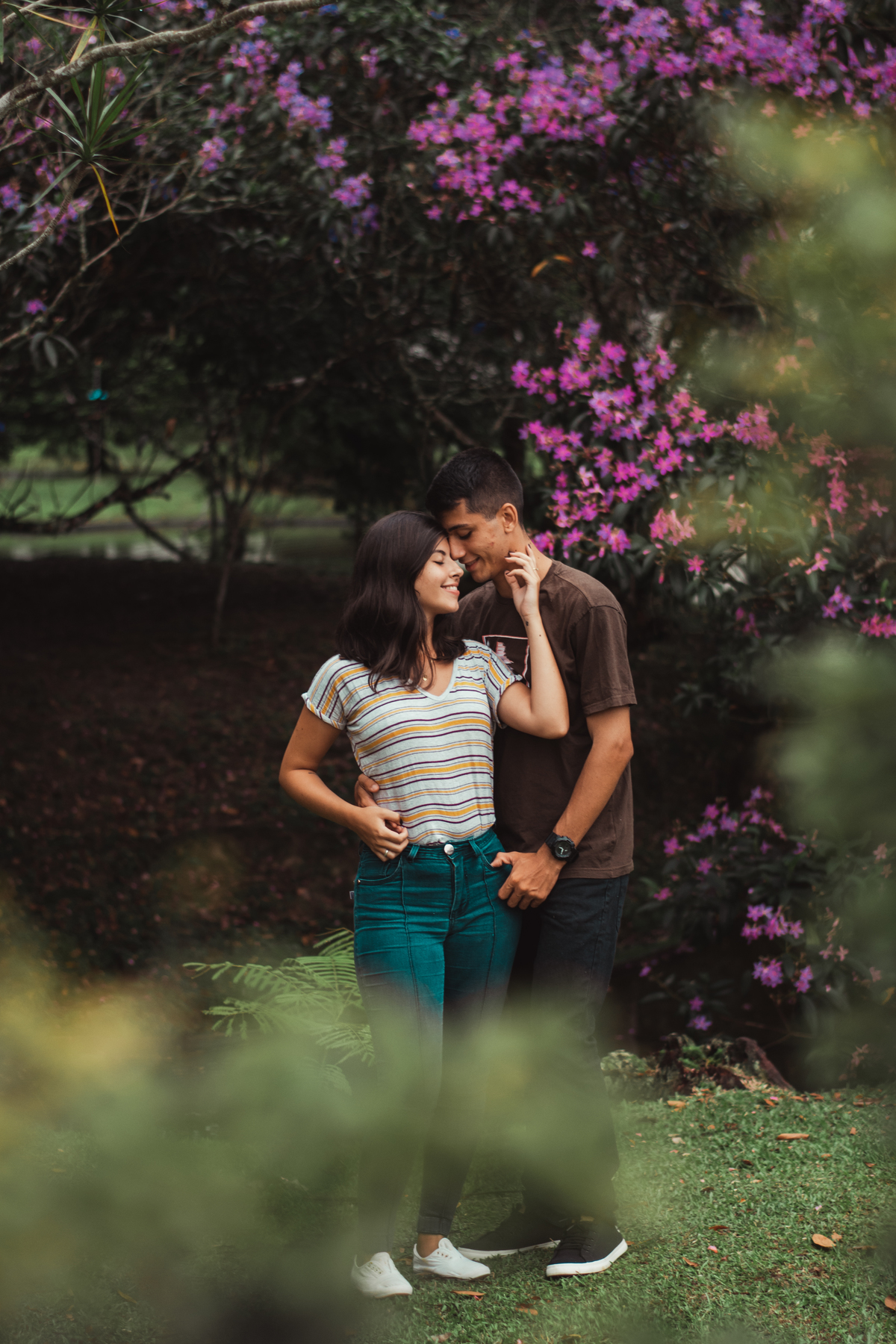 casal se abraçando em meio ao campo, fundo de flores atras do casal, ensiao de casal no parque de france em joinville com cachorro, fotógrafo de ensaio de casal em joinville