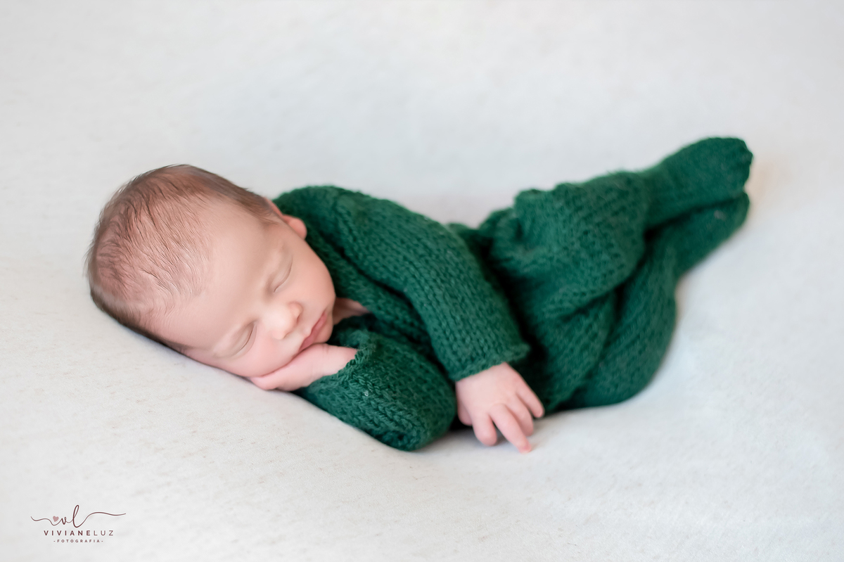fotografia newborn de menino verde e branco pose de ladinho macacao newborn fotografa de guaramirim recem nascidos jaragua do sul