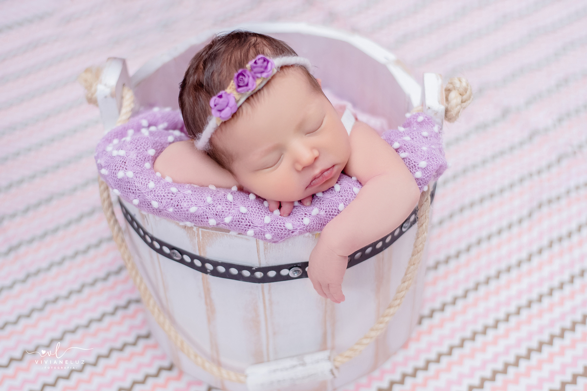 newborn lilas no baldinho pose de bracinho