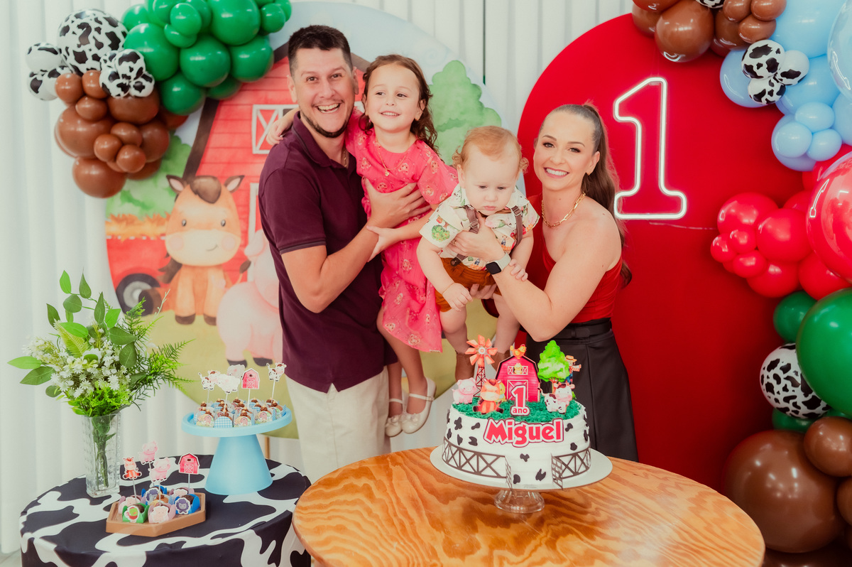 familia feliz no primeiro aninho do miguel com tema de fazendinha