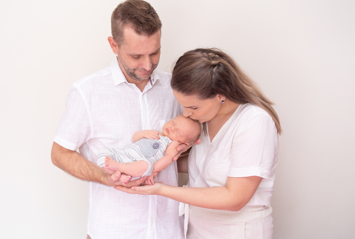 foto com os pais no newborn em casa com menino