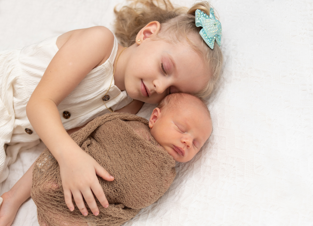 fotografia newborn em casa com irmãos foto com irmazinha