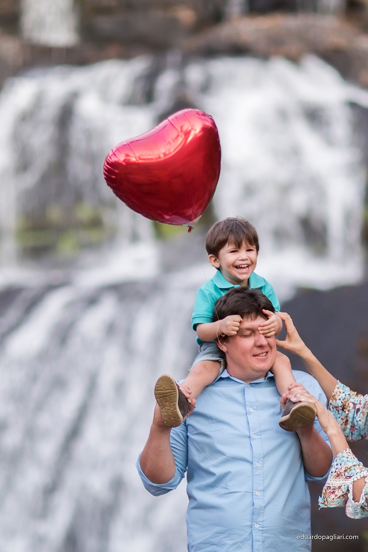 familia a beira da cachoeira com o filho