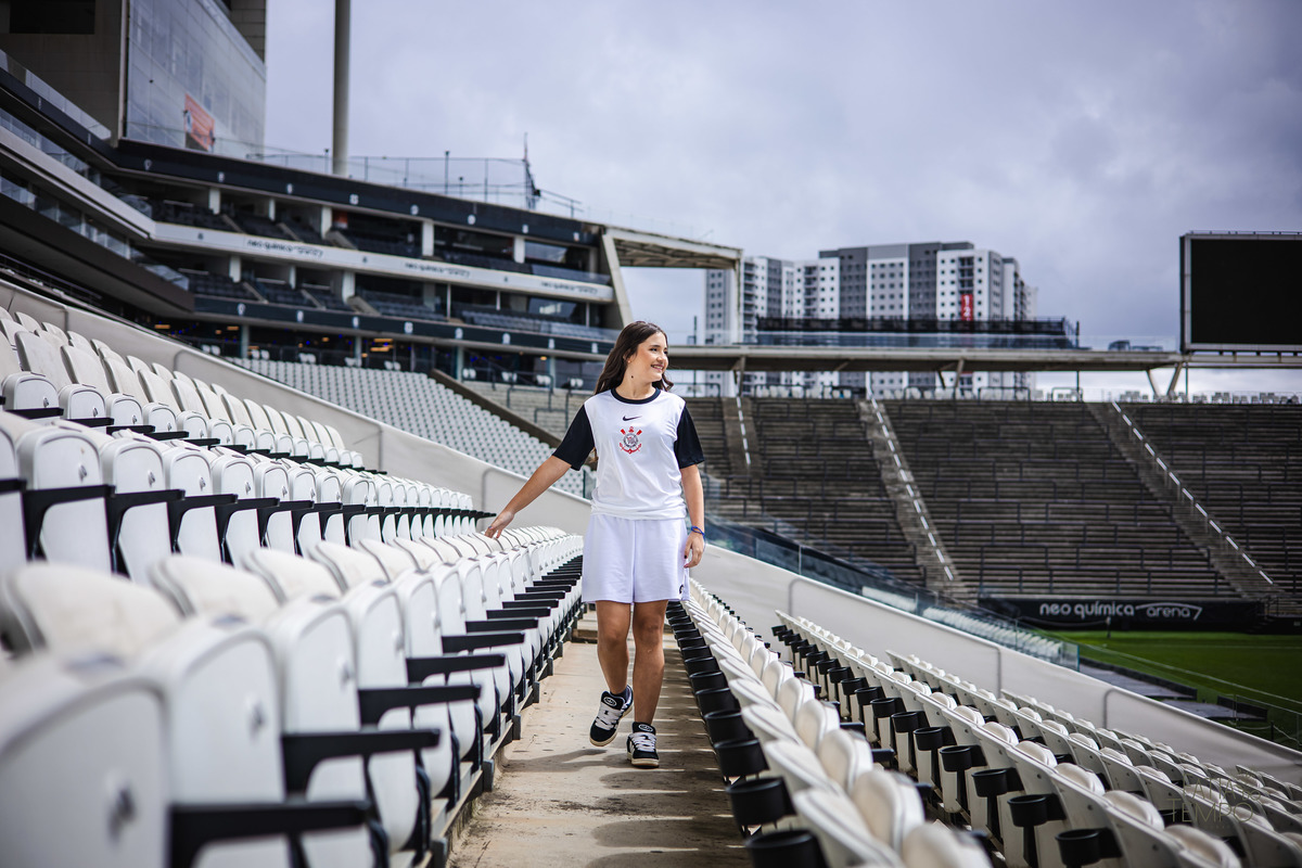debutante, 15 anos, ensaio fotográfico, Corinthians, Arena Corinthians, futebol, estádio, torcedora, paixão, timão, uniforme, chuteira, arquibancada, campo, gramado, bola, emoção, juventude, beleza, sonho, celebração, fotografia, estilo, preto e branco