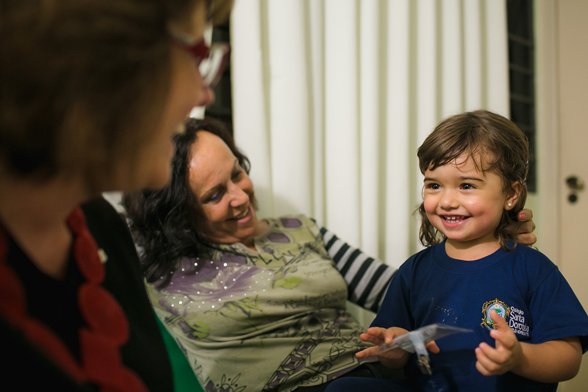 avós materna e paterna brincam com a neta que acabou de ganhar um irmão