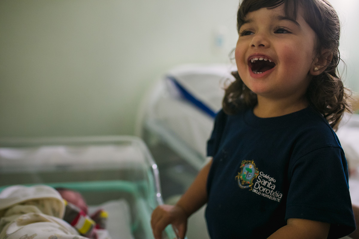 menina em felicidade intensa por ter recebido um irmão em foto feita por adrianacostafotos