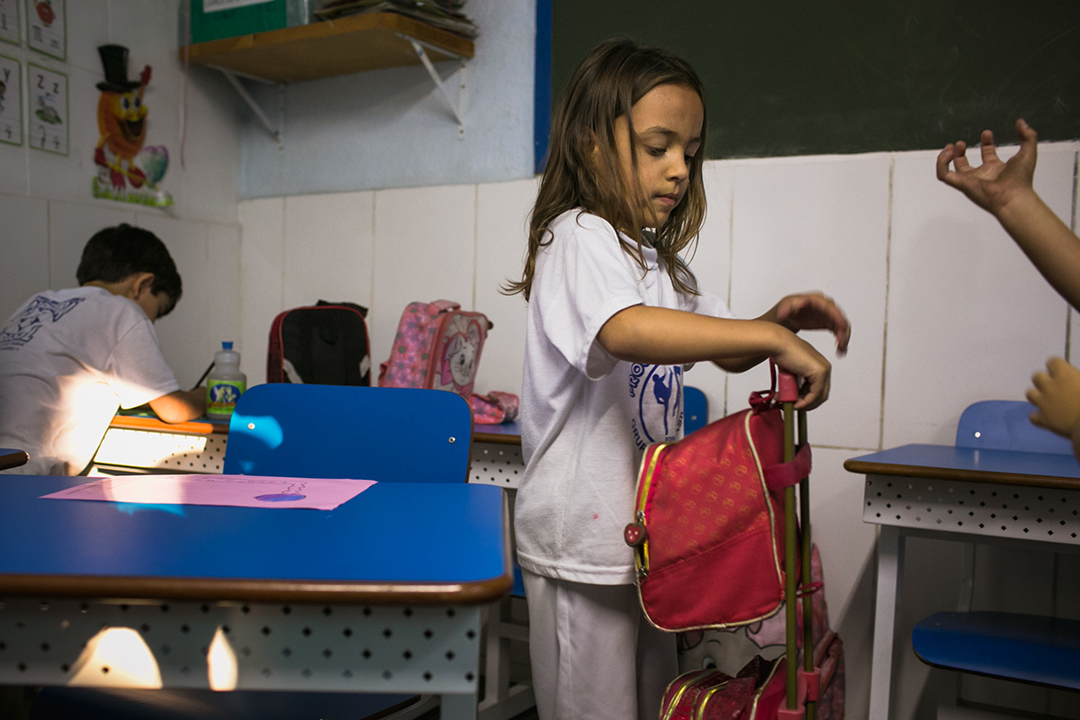 criança arrumando a pasta para sair da escola