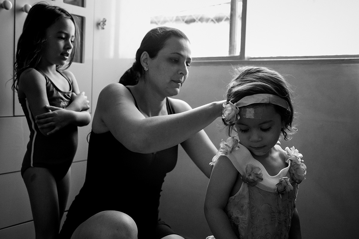 mãe ajudando filha a se fantasiar num registro documental de família