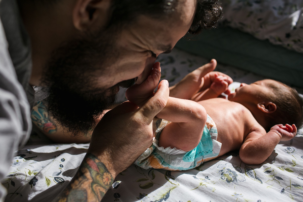 pai adorando brincar com o pezinho do seu bebê em uma foto feita por Adriana Costa