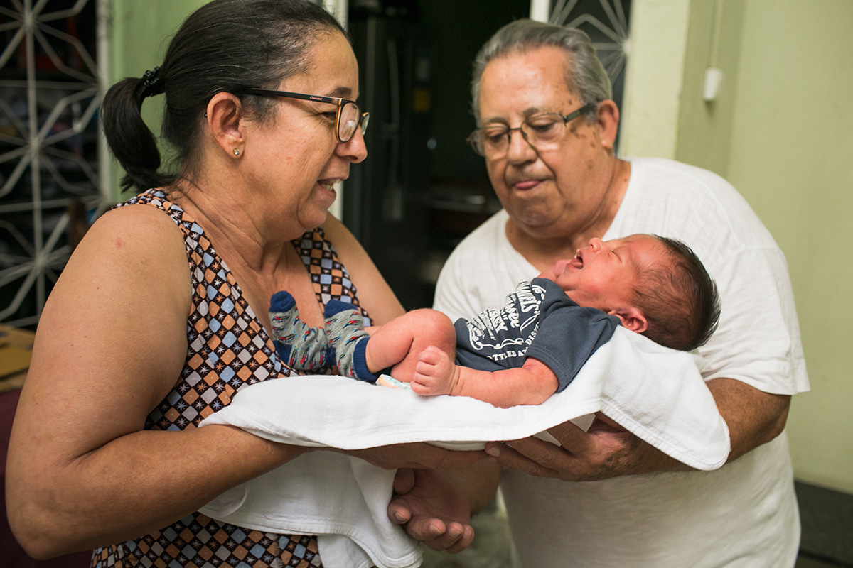 foto de Adriana Costa do avô pegando seu neto no colo pela primeira vez