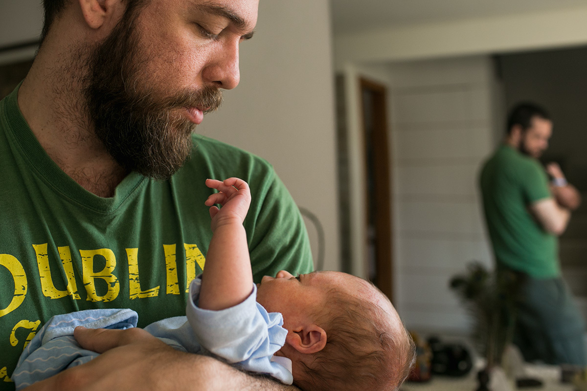 Foto de Adriana Costa do pai ninando seu bebê 