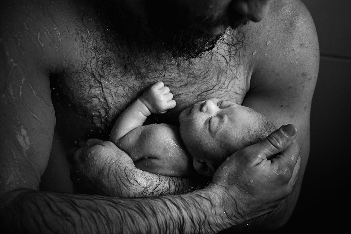 pai abraçado ao filho na hora do banho no chuveiro, por Adriana Costa