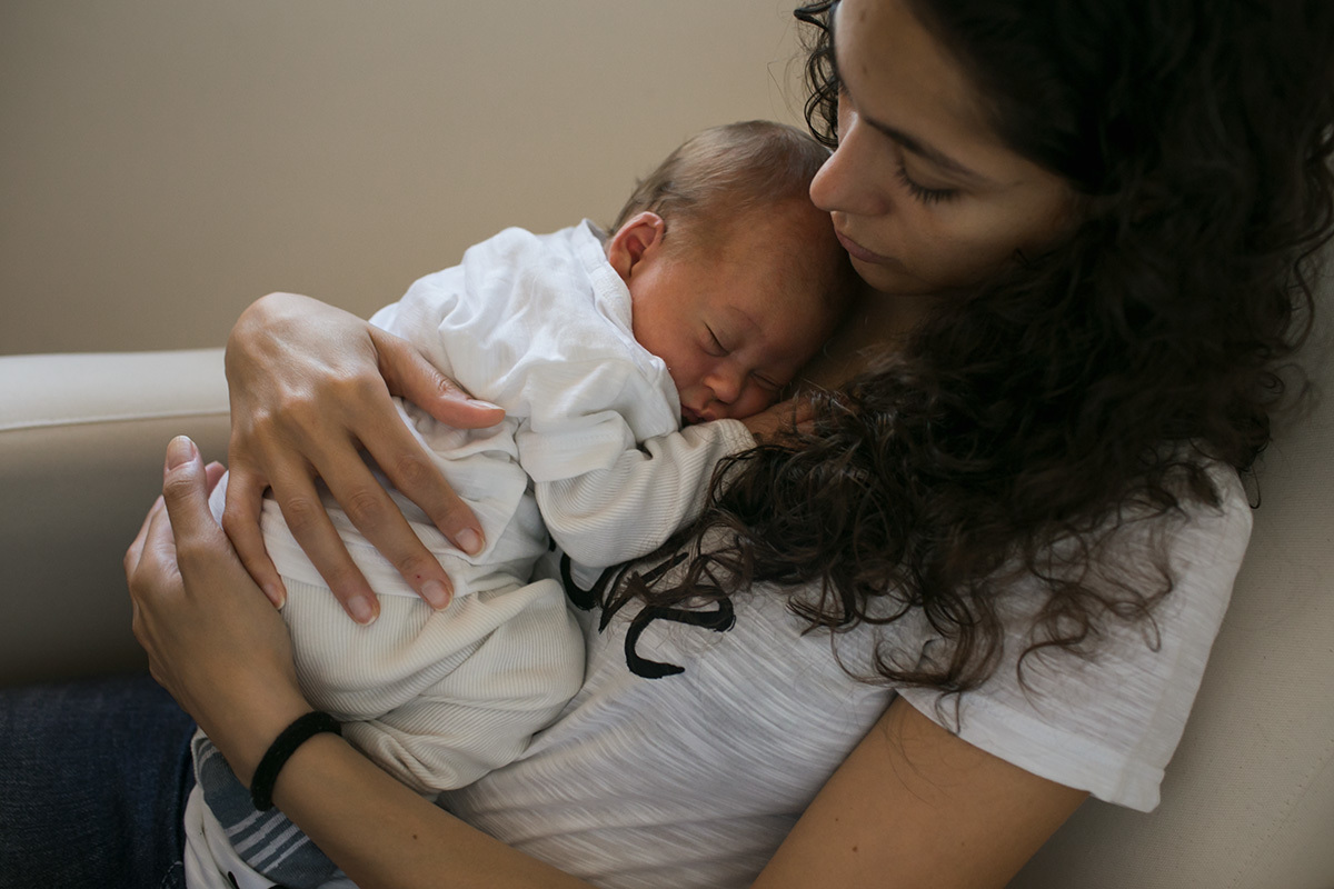 bebê aconchegado no colo da mãe após amamentação, por Adriana Costa